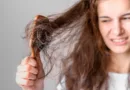 Kobieta martwi się o wypadające włosy podczas czesania się